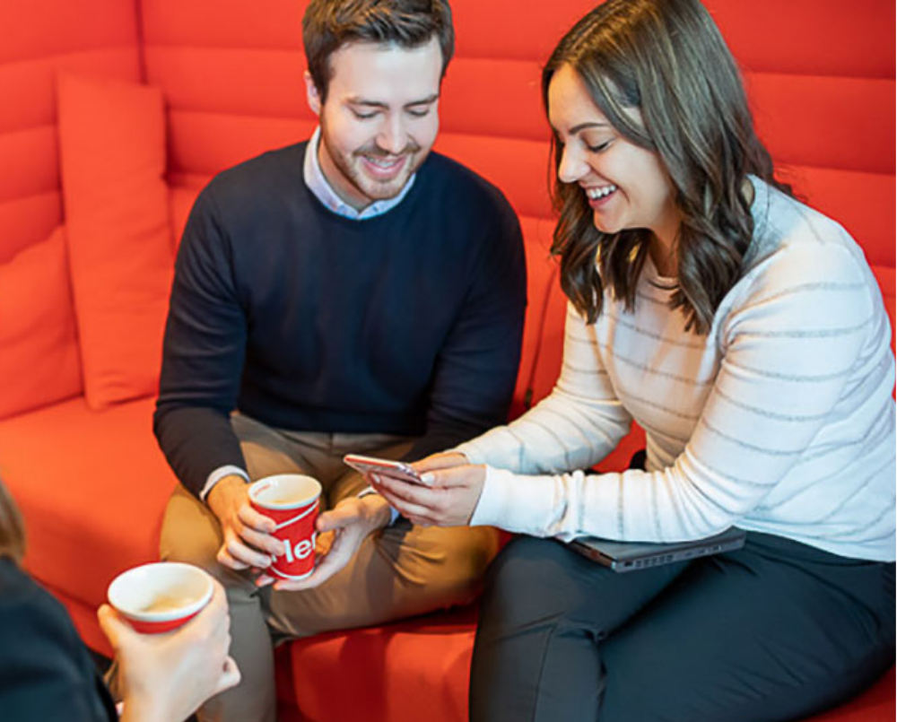 Three Henkel employees drink coffee and talk.