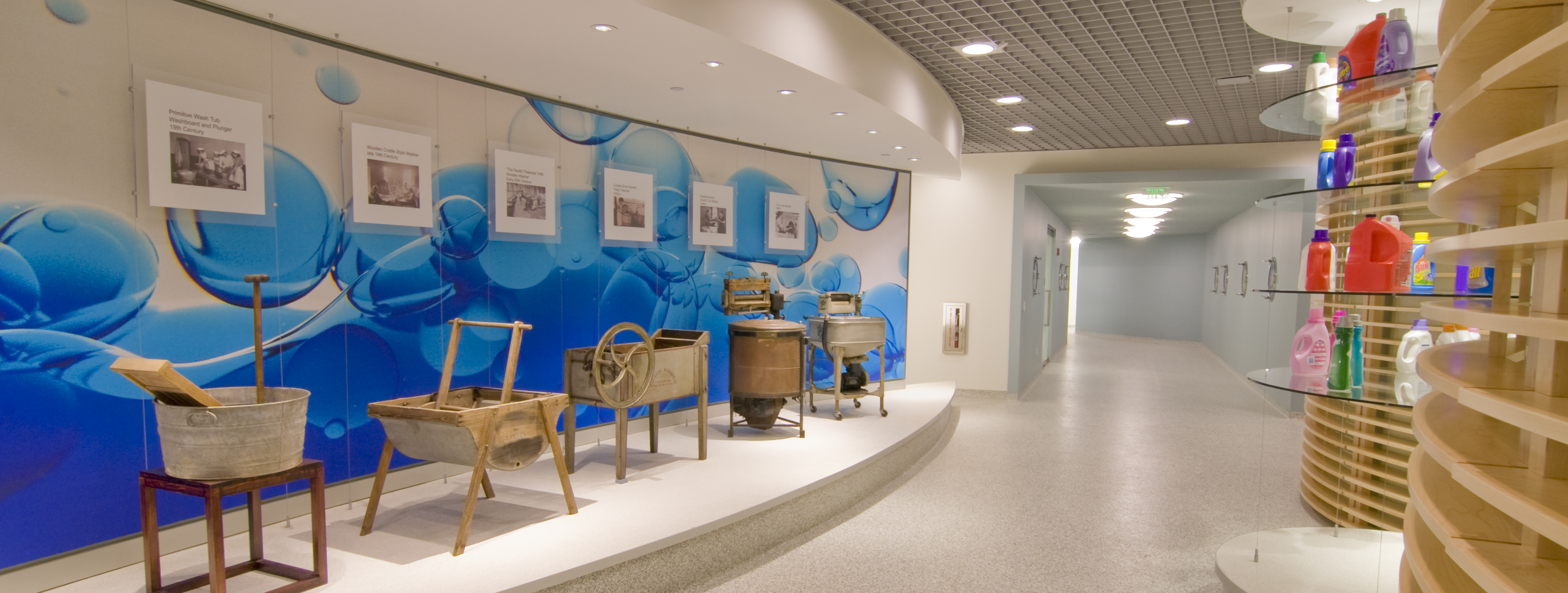 Antiquated tubs and basins displayed at the Trumbull site show how laundry methods have evolved over the years, opposite an impressive arrange of current Laundry & Home Care products