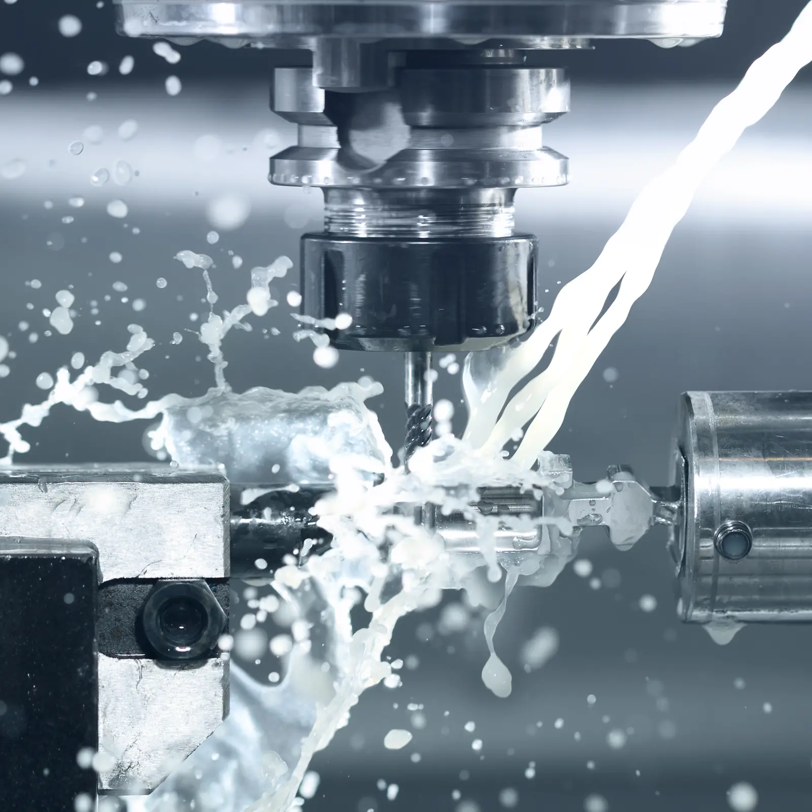 Black and white photo shows a drill with cooling spray water