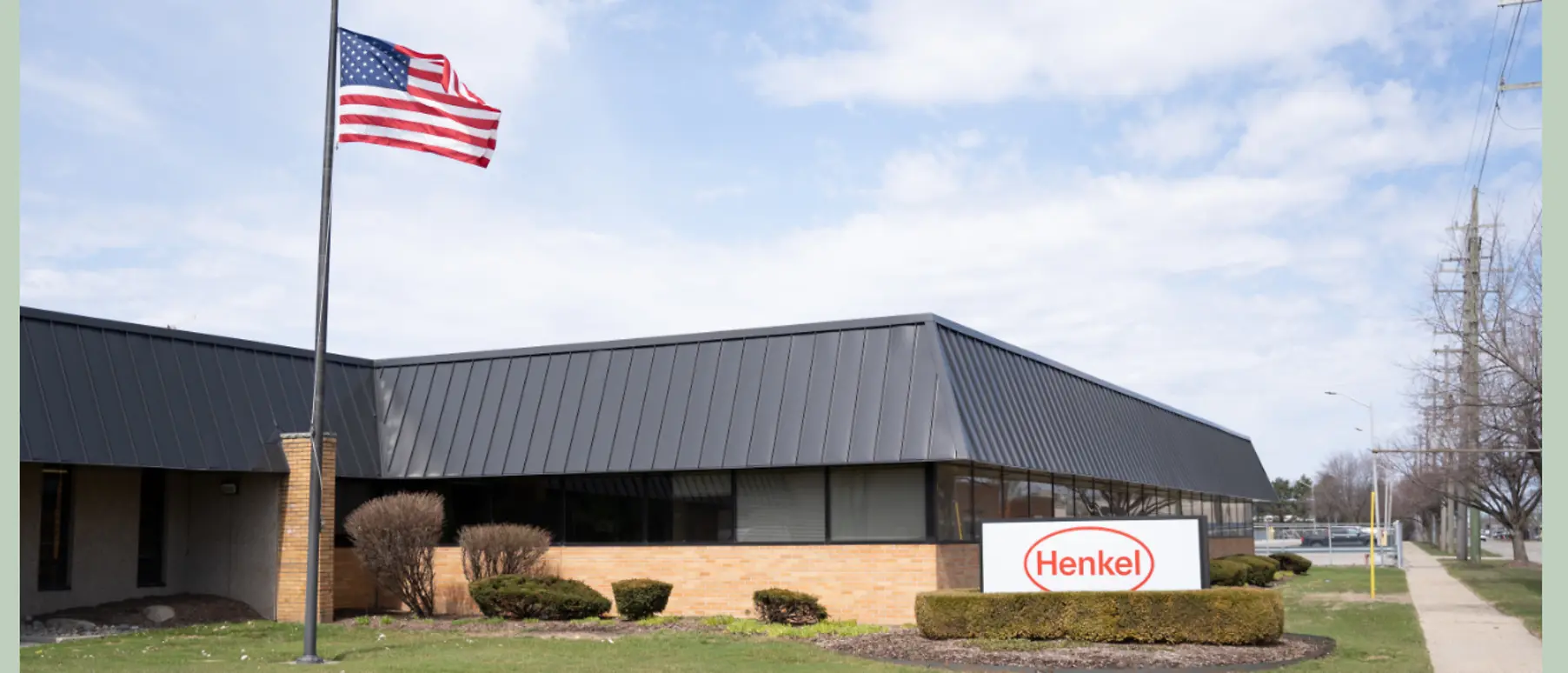 Building exterior with greenery and U.S. flag in front