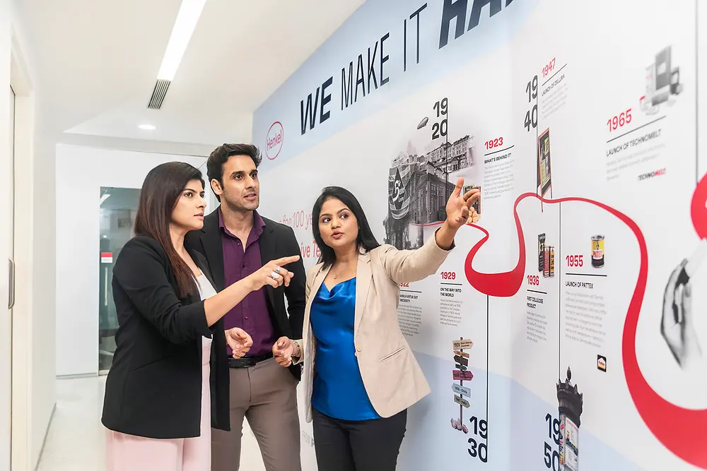 A customer experience tour guide shows a group of two customers the Technology Center Mumbai.